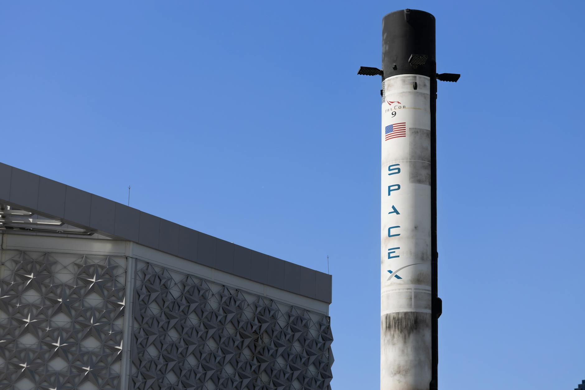 https://www.pexels.com/photo/space-x-rocket-and-building-exterior-against-blue-sky-12861275/